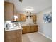 Efficient kitchen with wood cabinets and white appliances at 10926 N Lantana Ave, Tampa, FL 33612