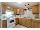 Efficient kitchen with wood cabinets and white appliances at 10926 N Lantana Ave, Tampa, FL 33612