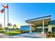 Fairway Village clubhouse entrance with flag and landscaping at 1100 Belcher S Rd # 190, Largo, FL 33771