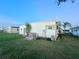 Rear view of the home showcasing the white siding and backyard at 1100 Belcher S Rd # 190, Largo, FL 33771