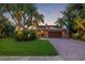 Evening view of two-story house with landscaping at 1124 Seville Ne Ln, St Petersburg, FL 33704