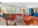 Bright living room with a cozy orange sofa, zebra-print rug, and built-in blue shelving at 1124 Seville Ne Ln, St Petersburg, FL 33704