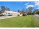 Single-story home with carport, fenced yard, and American flag at 12002 Washington St, Seffner, FL 33584