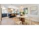 Modern kitchen with a round dining table, dark cabinets, and stylish light fixtures at 1291 Golden Oak Dr, Tarpon Springs, FL 34689