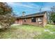 Brick house back view, featuring a patio and yard space at 1406 N Riverhills Dr, Temple Terrace, FL 33617