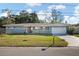 Single story home with gray exterior, attached garage and a well-maintained lawn at 1571 Jeffords St, Clearwater, FL 33756