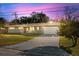 Ranch style home with gray exterior, attached garage and a front yard at dusk at 1571 Jeffords St, Clearwater, FL 33756