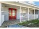 Inviting front porch with red door, white railings, and tiled flooring at 1571 Jeffords St, Clearwater, FL 33756