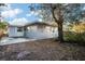 Gray house exterior with a back patio and large tree at 1571 Jeffords St, Clearwater, FL 33756