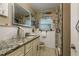 Bathroom with granite vanity, walk-in shower, and decorative accents at 1611 San Charles Dr, Dunedin, FL 34698