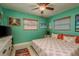 Bedroom with coral bedding, ceiling fan, and flat screen TV at 1611 San Charles Dr, Dunedin, FL 34698