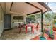 Covered patio with red table and chairs, view of backyard at 1611 San Charles Dr, Dunedin, FL 34698