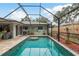 Relaxing screened pool area with brick pavers and lush landscaping at 1611 San Charles Dr, Dunedin, FL 34698