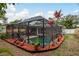 Screened pool area with patio furniture and tropical landscaping at 1611 San Charles Dr, Dunedin, FL 34698