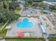 Aerial view of a large community pool with lounge chairs and umbrellas near a parking area at 2258 World Parkway W Blvd # 8, Clearwater, FL 33763