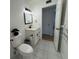 This half bath includes decorative vanity lights and a framed mirror and towel hooks at 2258 World Parkway W Blvd # 8, Clearwater, FL 33763