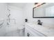 All-white bathroom boasts tile floors, shower-tub combo, and a modern sink with bright vanity lighting at 2258 World Parkway W Blvd # 8, Clearwater, FL 33763