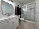 Bright bathroom featuring tile floors, white vanity, a dark wood cabinet, and a walk-in shower at 2258 World Parkway W Blvd # 8, Clearwater, FL 33763