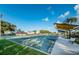 Community bocce ball court, benches, a shaded canopy, green landscaping, and nearby parking at 2258 World Parkway W Blvd # 8, Clearwater, FL 33763