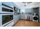 Bright kitchen with gray cabinets, stainless appliances, wood floors, and washer/dryer hookup at 2258 World Parkway W Blvd # 8, Clearwater, FL 33763