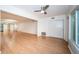 An open-concept living room featuring hardwood floors, a ceiling fan, and access to the dining area at 2258 World Parkway W Blvd # 8, Clearwater, FL 33763