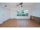 The living room is airy with hardwood floors, a large window overlooking the complex, and a ceiling fan at 2258 World Parkway W Blvd # 8, Clearwater, FL 33763