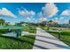 Community picnic area featuring sidewalks, picnic tables, trash cans, and lush landscaping at 2258 World Parkway W Blvd # 8, Clearwater, FL 33763