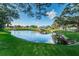 Scenic pond featuring lush landscaping and mature trees surrounding a charming gazebo at 2258 World Parkway W Blvd # 8, Clearwater, FL 33763