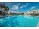 A large community pool with ample lounge chairs available for residents and guests at 2258 World Parkway W Blvd # 8, Clearwater, FL 33763