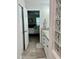 Bathroom with granite countertop, white cabinets, and a glass block shower at 3053 Overlook Pl, Clearwater, FL 33760
