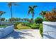 Walkway leading to waterfront with lush landscaping and palm trees at 380 Aruba Cir # 203, Bradenton, FL 34209