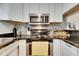 Modern kitchen with stove, microwave, and granite countertops at 4250 37Th S St # 5, St Petersburg, FL 33711