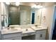 Double vanity bathroom with white cabinets, large mirror, and a walk-in shower at 5426 Rushmere Ct, Palmetto, FL 34221