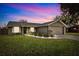 House exterior at dusk showcasing landscaping and garage at 6233 Florida E Cir, Apollo Beach, FL 33572