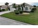 Single-story home with a landscaped lawn and palm trees at 6769 Greenview Ln, Englewood, FL 34224