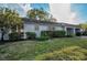 Side view of the house showcasing its light gray exterior and neat lawn at 8236 Brentwood Rd, Seminole, FL 33777