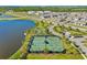 Aerial view of community tennis and basketball courts, lake, and homes at 9512 Lemon Drop Loop, Ruskin, FL 33573