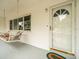 Front porch with white swing and door at 9909 48Th N Ave, St Petersburg, FL 33708