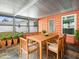 Screened porch with wooden dining set and potted plants at 9909 48Th N Ave, St Petersburg, FL 33708