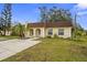 Tan house with brown roof, palm trees, and a grassy yard at 9941 85Th St, Seminole, FL 33777