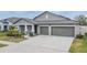 One-story home with gray exterior, two-car garage, and landscaped yard at 10832 Sage Canyon Dr, Riverview, FL 33578