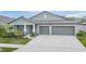 One-story home with gray exterior, two-car garage, and landscaped yard at 10832 Sage Canyon Dr, Riverview, FL 33578