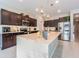 Modern kitchen with large island, dark cabinetry, and stainless steel appliances at 10832 Sage Canyon Dr, Riverview, FL 33578