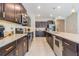 Modern kitchen with dark cabinetry, expansive countertops, and stainless steel appliances at 10832 Sage Canyon Dr, Riverview, FL 33578