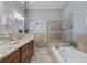 Bathroom features a walk-in shower, soaking tub, and double vanity at 1109 Pinellas Bayway S # 403, Tierra Verde, FL 33715