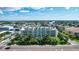 Aerial view of a modern building near the coast, with lush landscaping and ocean views at 11605 Gulf Blvd # 302, Treasure Island, FL 33706