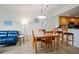 Dining area with glass table, wooden chairs, and a modern chandelier at 11605 Gulf Blvd # 302, Treasure Island, FL 33706