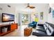 Living room with blue sofa, wooden tv stand and ocean view at 11605 Gulf Blvd # 302, Treasure Island, FL 33706