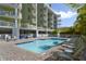 Inviting pool area with lounge chairs and building view at 11605 Gulf Blvd # 302, Treasure Island, FL 33706