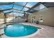 Inviting kidney-shaped pool with a screened enclosure and cascading waterfall feature at 12509 Bay Branch Ct, Tampa, FL 33635